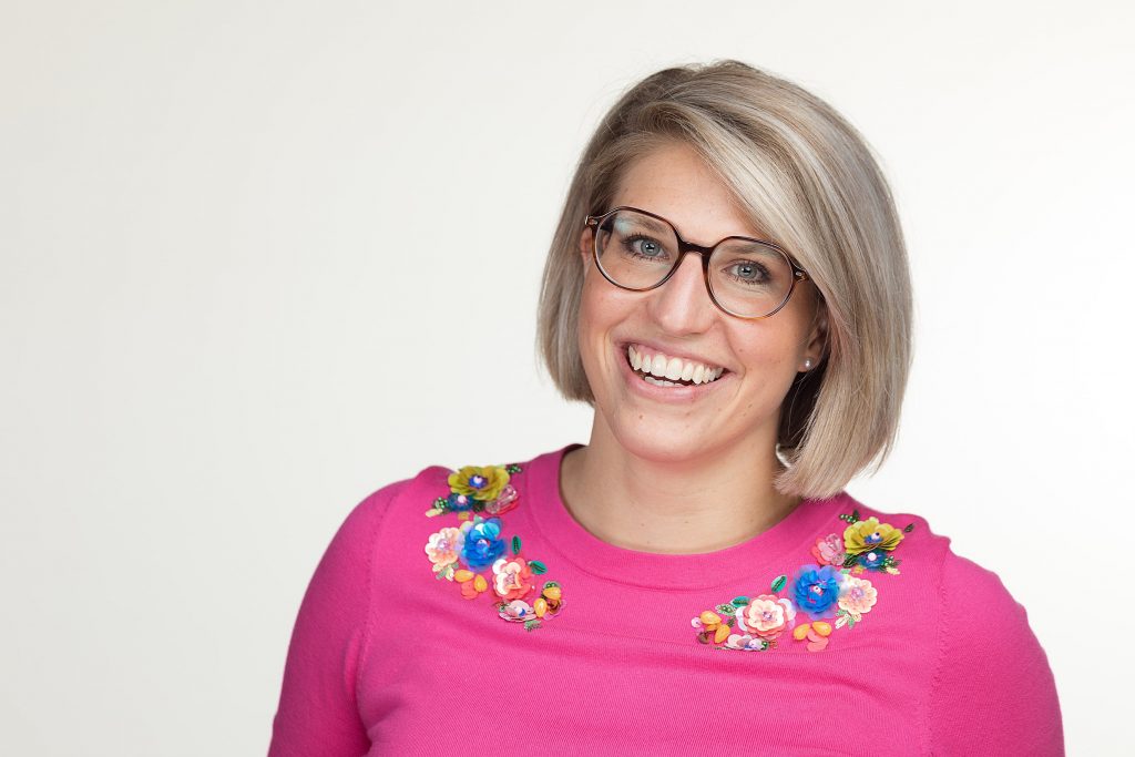 Author and coach Katharina Stuerzl gives off positive vibes with a brightly colored top and a big smile in this professional headshot.