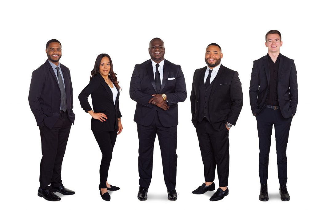 5 team members of a Berks County real estate agency in a composite staff photo, wearing dark suits against a white background. 