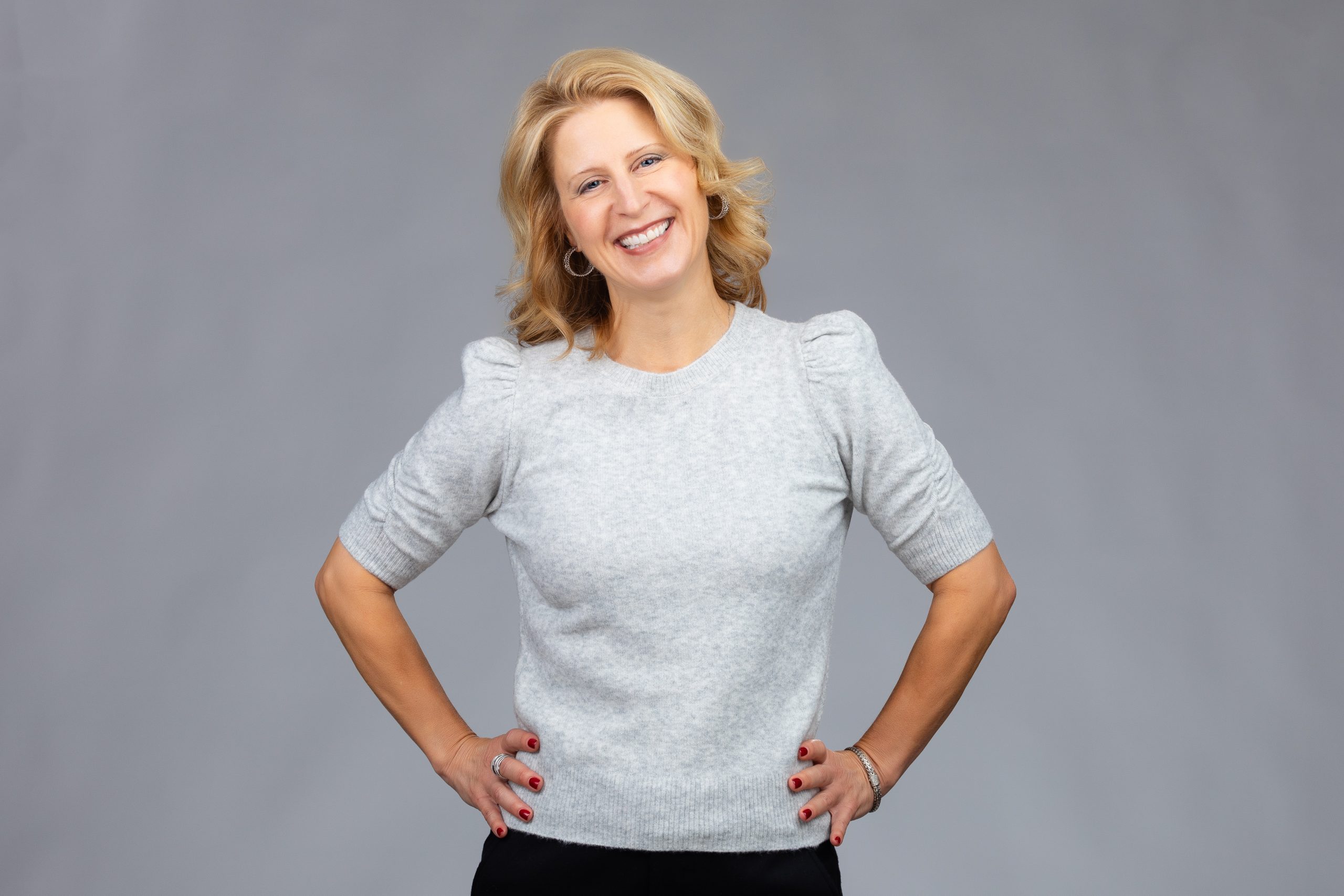 Smiling business woman against a grey background