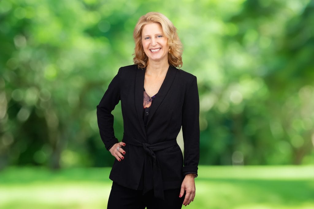 Smiling business woman in a suit with an AI background