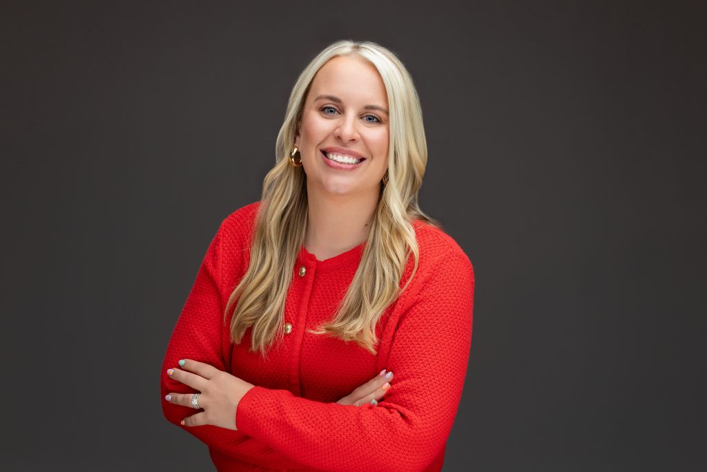 Headshot of real estate agent with crossed arms smiling. 