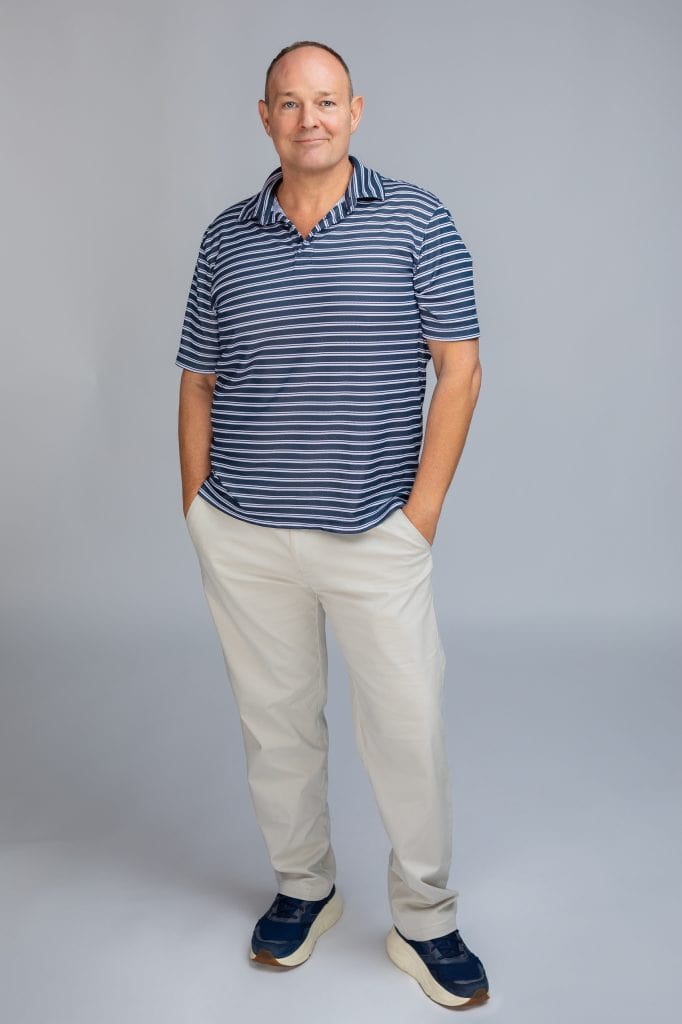 Studio headshots for actors: full length photo of a smiling male actor against a neutral backdrop