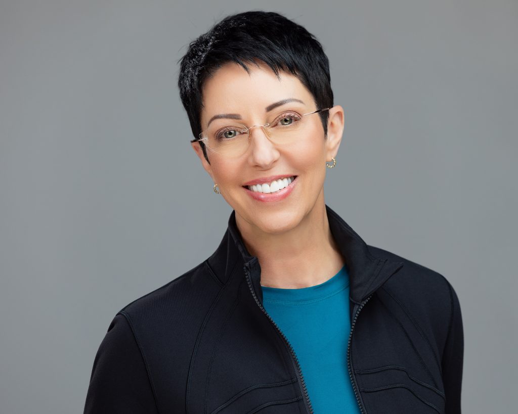 Rhonda Torres' headshot for PEAK Integrative Medicine, in which she is wearing a teal blue shirt that matches the rest of the team's headshot colors