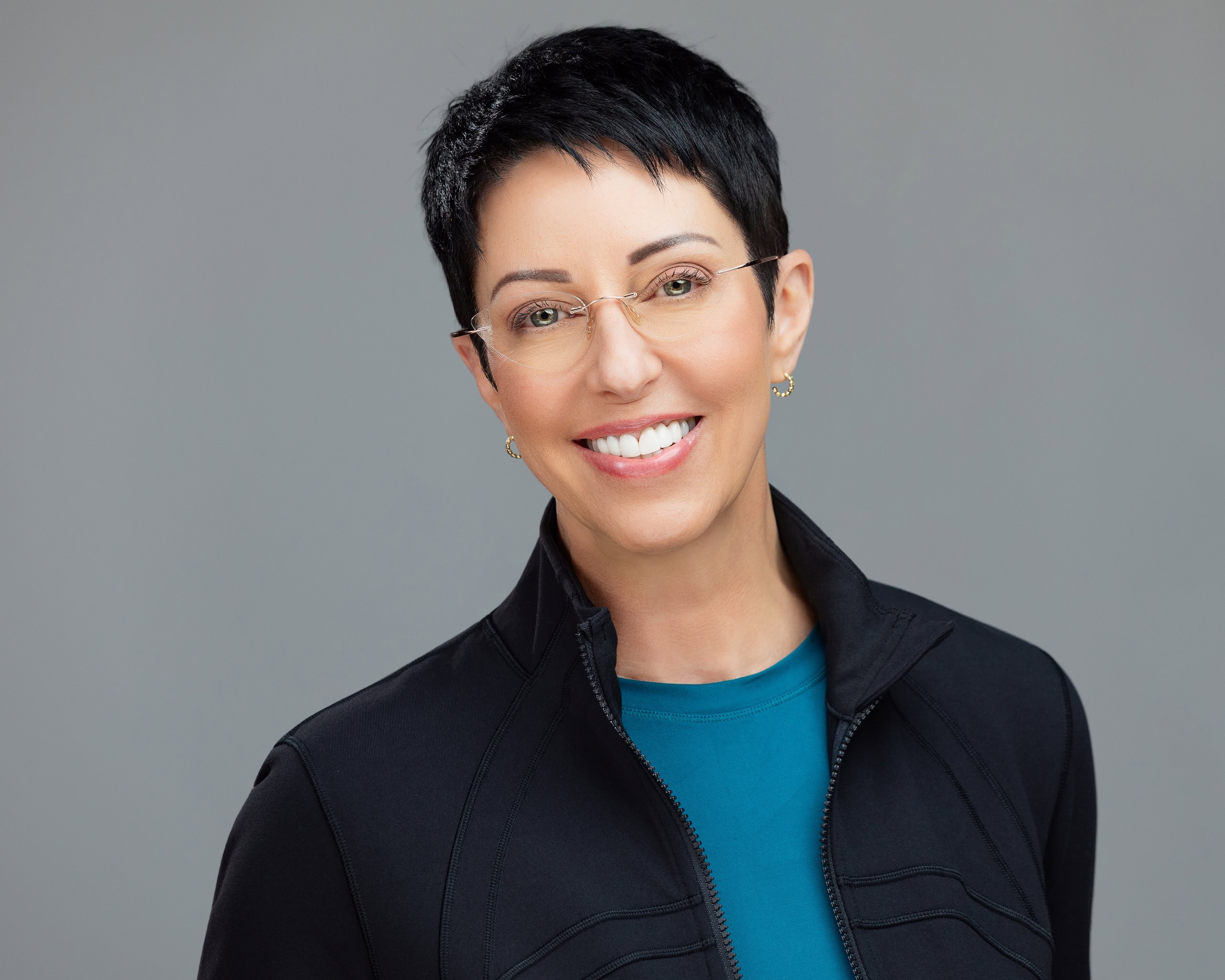 Rhonda Torres' headshot for PEAK Integrative Medicine, in which she is wearing a teal blue shirt that matches the rest of the team's headshot colors