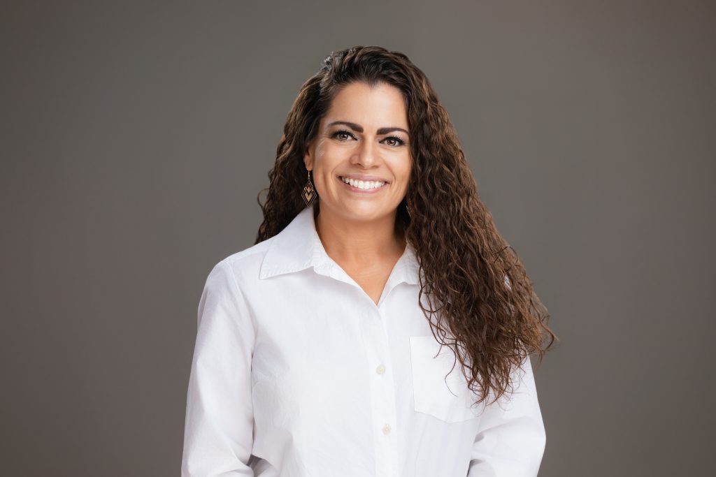Headshot of a smiling business woman on grey background