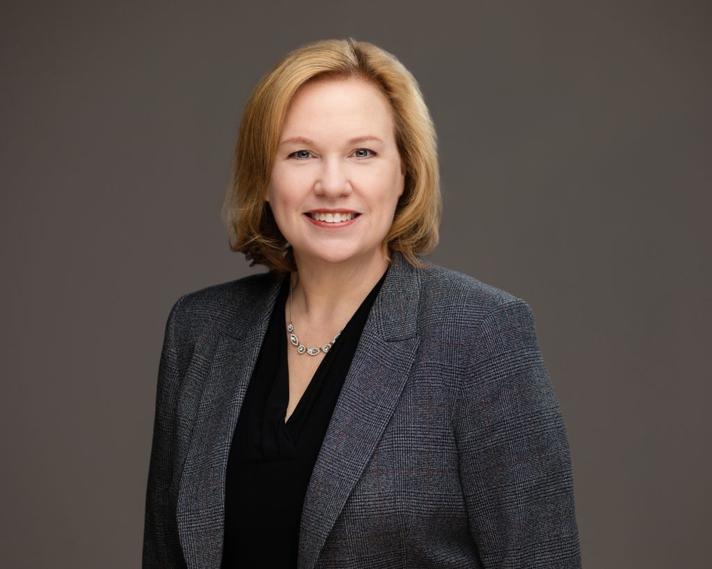 Attorney headshot of a professional woman with a dark shirt and jacket. 