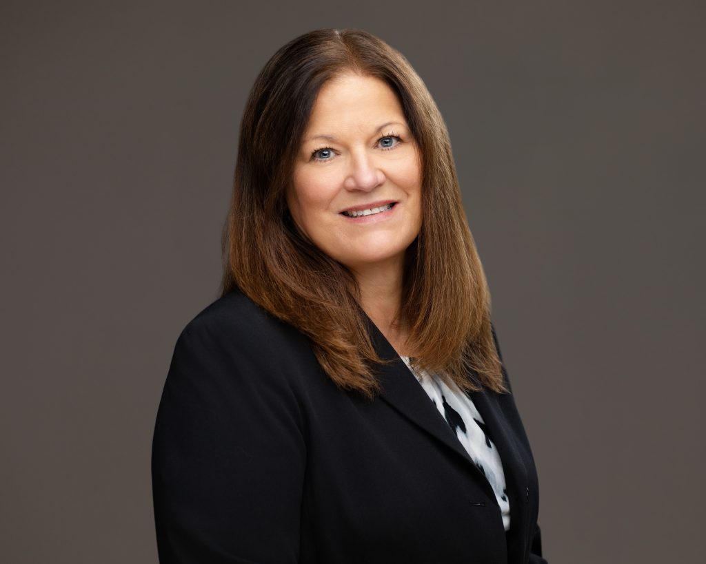 Attorney headshot of a professional woman with a dark shirt and jacket. 