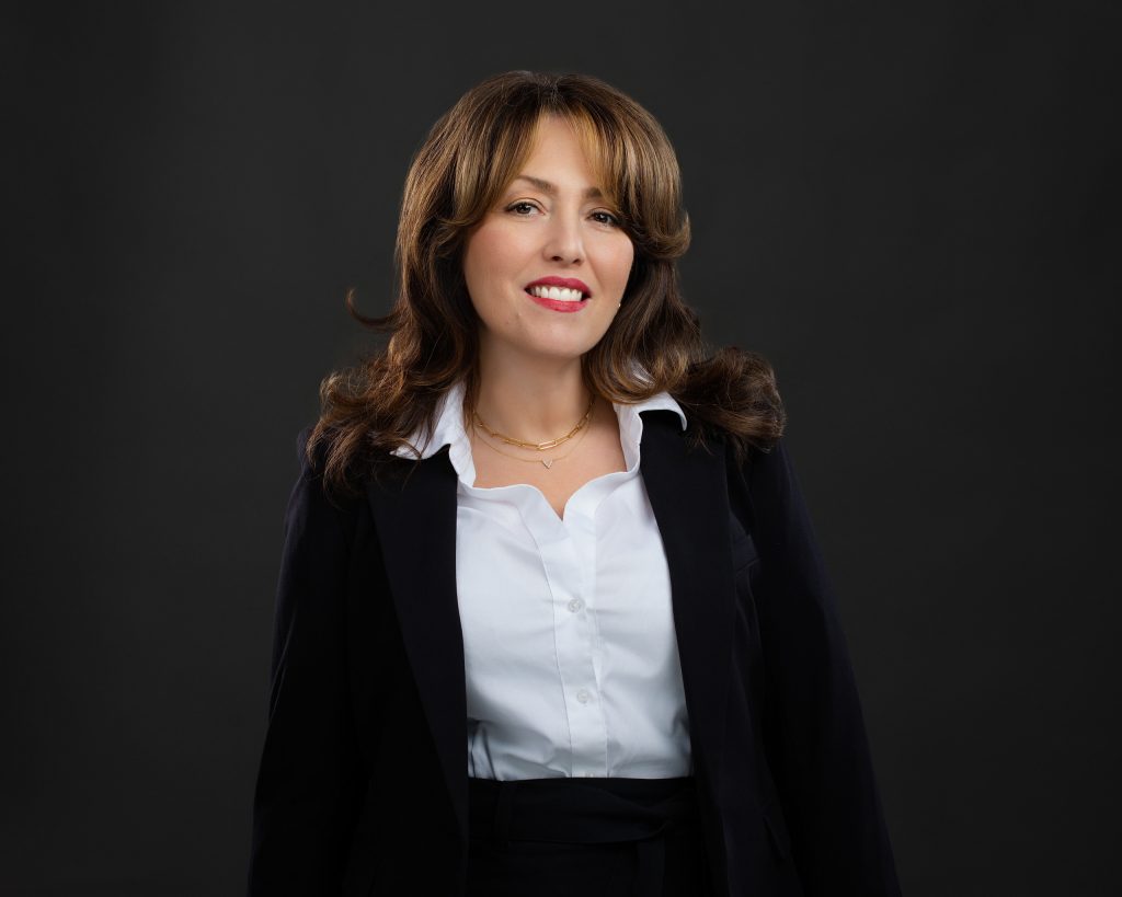 Headshot of a woman who works in financial services. She's looking straight at the camera with a friendly and confident expression. 