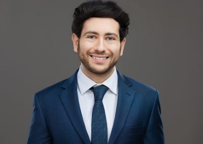 Therapist headshot of young man wearing a suit and smiling